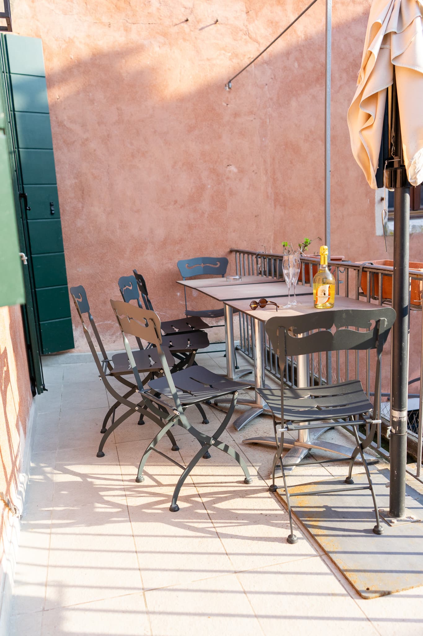 Private terrace Emerald Venice palazzo - outdoor dining, metal bistro chairs, sunset view