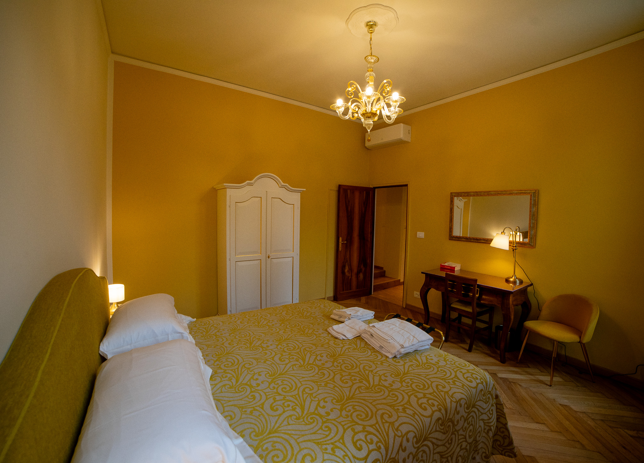 Gold bedroom Venice luxury apartment - golden Murano chandelier, herringbone floor, antique furniture